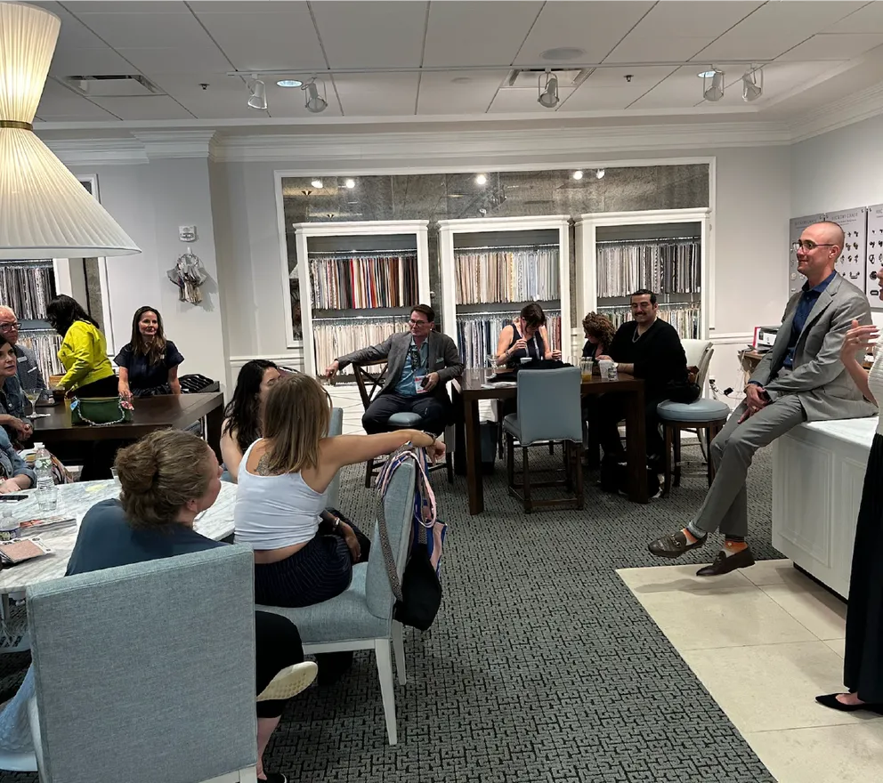 Traci Connell speaking to a room of design professionals in a fabric showroom.