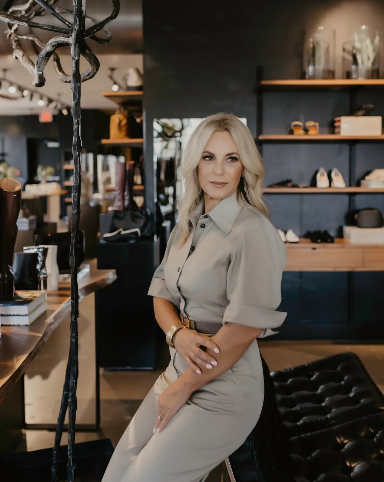 Traci Connell standing in a boutique with shelves of shoes and accessories behind her.