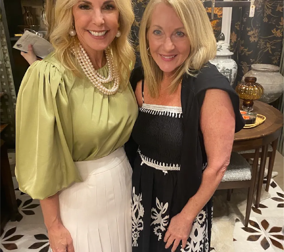 Traci Connell smiling beside an interior designer at a showroom event.